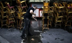 Un employé nettoie la terrasse d'un café à Paris le 12 mai en vue de la réouverture des terrasses le 19 mai 2021