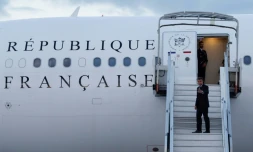 Le président français Emmanuel Macron fait un signe de la main en embarquant dans son avion présidentiel pour se rendre en Nouvelle-Calédonie, à l'aéroport d'Orly, en banlieue de Paris, le 21 mai 2024