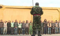 Le chef de la police militaire d'Alep s'adresse à un groupe d'hommes détenus dans une base militaire à Alep, le 11 décembre 2016