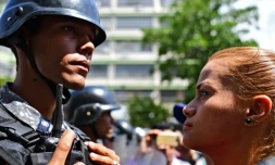 Une partisane du président autoproclamé vénézuelien Juan Guaido fait face à un policier lors d'une manifestation à Caracas le 9 mars 2019