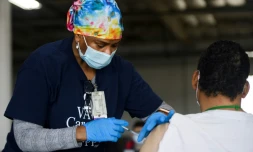 Une infirmiĂšre administre une dose de vaccin Ă un patient le 17 avril 2021 Ă Gardena (Etats-Unis)