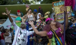 Des danseurs lÚvent les bras au ciel au sein du cortÚge "Loucura suburbana", pendant le carnaval de Rio, le 8 février 2018
