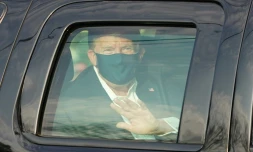 Le président américain Donald Trump salue ses symathisants depuis la limousine présidentielle lors d'une brève sortie de l'hôpital militaire de Walter Reed à Bethesda, près de Washington, le 4 octobre 2020                    