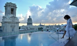 Une touriste au bord de la piscine sur le toit de l'hôtel Gran Manzana Hotel à La Havane, le 11 février 2019