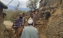 Des pakistanais se rassemblent près des décombres de plusieurs maisons, après un puissant séisme à Bajaur, au Pakistan, le 26 octobre 2015