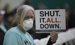 Une femme tient une pancarte pendant un rassemblement au sujet d'une fuite de gaz massive, Ă Granada Hills, prĂšs de Porter Ranch, en Californie, le 16 janvier 2016