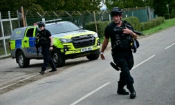 Des policiers armés devant la base de la RAF à Fairford, le 28 septembre 2026, dans le sud-ouest de l'Angleterre, au lendemain de l'intervention de la police antiterroriste britannique