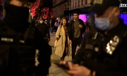 Des badauds sans masque passent à côté d'un contrôle de police sur les Champs Elysées à Paris, le 31 décembre 2021
