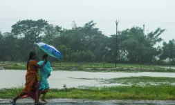 Deux femmes marchent sur la route avant l'arrivée du cyclone Amphan, à Midnapore, en Inde, sur le golfe du Bengale, le 20 mai 2020