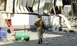 Un membre des forces progouvernementales yéménites dans une zone industrielle détruite par les combats le 19 novembre 2018 dans la ville portuaire de Hodeida cruciale pour l'arrivée de l'aide humanitaire