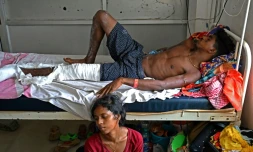 Blessé dans l'accident ferroviaire qui a frappé l'Inde, Gura Palai, est admis au Fakir Mohan Medical College and Hospital, et son épouse est assise à ses côtés, le 5 juin 2023. Des familles recherchaient toujours leurs proches disparus dans la catastrophe ferroviaire qui a fait au moins 288 morts en Inde