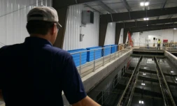 Lance Lin, directeur de la Rare Earth Elements Initiative de l'Université de Virginie-Occidentale, devant les bassins d'une installation de traitement de drainage minier acide, le 12 août 2026 à Mount Storm, en Virginie-Occidentale (Etats-Unis)