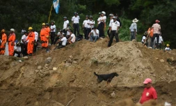 Des secouristes, pompiers et habitants sur les lieux d'un glissement de terrain à Santa Catarina Pinula, à 15 km à l'est de Guatemala, le 2 octobre 2015
