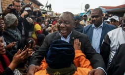 Le président sud-africain Cyril Ramaphosa salue des partisans en allant voter à Soweto, le 8 mai 2019.