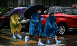 à l'abri de la pluie à Pékin le 31 juillet 2023.