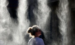 Une femme se rafraîchit sous un brumisateur à l'occasion de la Fête de la Musique à Bordeaux, en Gironde, pendant un épisode de canicule en France, le 21 juin 2026