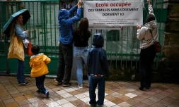 Des parents d'élèves attachent une banderole sur la clôture de l'école du Pas Saint-Georges, dans le centre de Bordeaux, le 9 octobre 2024