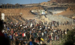 Des Palestiniens rassemblés à un point de distribution d'aide de la Fondation humanitaire de Gaza (GHF), près du camp de réfugiés de Nousseirat, dans le centre de la bande de Gaza, le 25 juin 2025