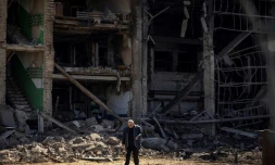 Un homme marche prÚs d'un bùtiment à la façade effondrée du complexe militaro-industriel de la société Vizar, aprÚs que le site a été touché par des frappes russes nocturnes dans la banlieue de Kiev, le 15 avril 2022.