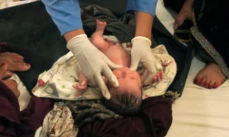 Une sage-femme afghane de Médecins sans Frontières (MSF) vérifie l'état de santé d'un nouveau-né dans une maternité, le 8 août 2018 à Khots, en Afghanistan