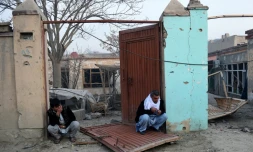 Des Afghans devant leur maison détruite à Kaboul, le 2 janvier 2016 conséquence de l'attentat contre le restaurant français