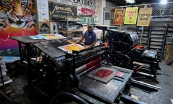 Jaime Garcia imprime des affiches sur la machine française Marinoni de 1870 à l'imprimerie La Linterna, le 4 mars 2021 à Cali, en Colombie