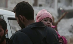 Un enfant syrien et son pÚre se préparant à évacuer une des derniÚres zones rebelles dans la Ghouta orientale, prÚs de Damas. Photo prise à Arbine,le 24 mars 2018
