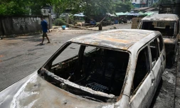 Des véhicules incendiés dans une rue de Rangoun en Birmanie le 15 mars 2021 au lendemain de manifestations contre le coup d'Etat militaire durement réprimées