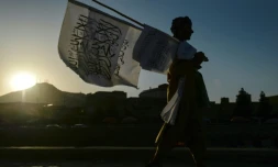 Un homme qui vend des drapeaux des talibans marche dans une rue de Kaboul le 15 septembre 2021