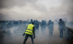 Un "gilet jaune" face à des policiers anti-émeutes, sur un pont parisien le 5 janvier 2019