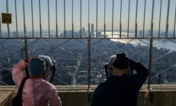 Des visiteurs admirent la vue depuis le 86ème étage de l'Empire State Building à New York, le 9 novembre 2021, au lendemain de la réouverture des frontières américaines aux voyageurs européens notamment