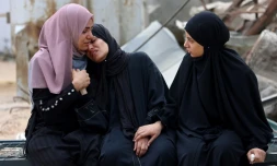Des Palestiniennes la mort d'un proche tué près d'un centre de distribution d'aide dans la bande de Gaza, le 24 juin 2025
