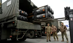 Des soldats ukrainiens chargent sur un camion des missiles FGM-148 Javelin anti-tanks livrés par avion par les Etats-Unis à l'aéroport Boryspil de Kiev, le 11 février 2022