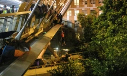 A protester (C) lowers herself down a rope from a bridge to a highway to escape from the campus of Hong Kong Polytechnic University
