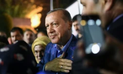 Le président Erdogan (c), accompagné de sa femme Emine, salue ses supporters en sortant du siège du parti AKP, le 16 avril 2017 à Istanbul