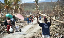 Des Haïtiens dans une rue dévastée aprÚs le passage de l'ouragan Matthew le 10 octobre 2016 à Les Cayes