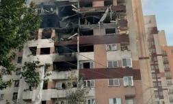 Des passants sont rassemblés devant un bâtiment visé par une frappe israélienne dans la capitale iranienne, Téhéran, le 13 juin 2025