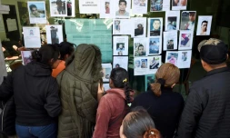 Des personnes cherchent les noms de leurs proches sur la liste des disparus dans l'explosion d'un oléoduc perforé par des voleurs de carburants, à Tlahuelilpan, dans le centre du Mexique, le 20 janvier 2019