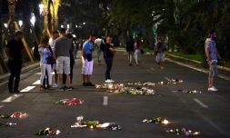 Photographie d'archive du 17 juillet 2016, montrant des bougies et des fleurs déposées en hommage aux victimes de l'attentat de Nice, survenu trois jours plus tôt