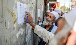 Un retraité vérifie une liste devant un bâtiment gouvernemental à Kabou, le 25 août 2025 en Afghanistan