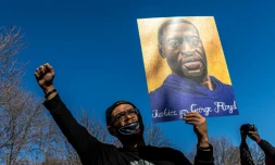 Un manifestant brandit un portrait de George Floyd Ă St. Paul, ville jumelle de Minneapolis, le 6 mars 2021