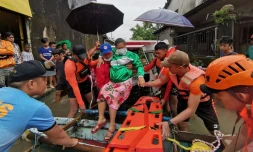 Photo non datĂ©e diffusĂ©e le 11 avril 2022 par les gardes-cĂŽtes philippins d'une habitante Ă©vacuĂ©e d'une zone inondĂ©e aprĂšs le passage de la tempĂȘte Megi, le 11 avril 2022 Ă Abuyog, dans la province de Leyte