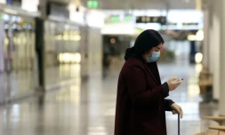 Une personne porte masque et gants dans un terminal vide à l'aéroport Franz-Josef-Strauss à Munich, le 28 avril 2020