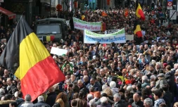 Le drapeau national belge et des pancartes lors de la marche pacifique contre le terrorisme à Bruxelles le 17 avril 2016