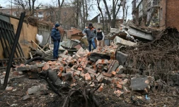 Des habitants de Kharkiv, dans le nord-est de l'Ukraine, marchent au milieu des débris d'un immeuble résidentiel, après une frappe de missiles le 25 novembre 2024