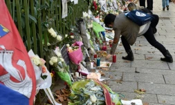 Des personnes déposent des fleurs et des bougies près du Bataclan après les attentats meurtriers, le 18 novembre 2015 à Paris