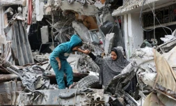 Une enfant joue au côté d'une Palestinienne dans les ruines d'un bâtiments détruit par un bombardement israélien, le 8 avril 2024 dans la ville de Gaza