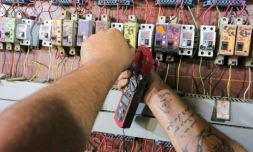 L'Irakien Aqeel Hassan, l'un des propriétaires de générateurs électriques privés, le 17 juillet 2021 en train de réparer les interrupteurs de son entreprise dans le quartier de Sadr City à Bagdad, qui alimente 270 foyers dans le quartier quand le réseau national défaillant tombe en panne