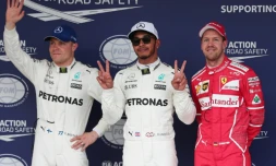 Le Britannique Lewis Hamilton (c) pose sur le podium après avoir obtenu la pole position du GP du Japon au volant de sa Mercedes, le 7 octobre 2017 à Suzuka