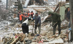 Des membres des services de secours et des habitants déblaient aprÚs une frappe russe, le 8 janvier 2024 à Zmiiv, dans la région de Kharkiv, en Ukraine